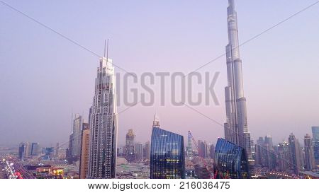 Aerial view of downtown Dubai in a summer day, United Arab Emirates. Aerial view of downtown Dubai with buildings skyscrapers and a dusty skyline at sunrise. Burj Khalifa.