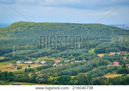 Summer rural landscape. Homes in the countryside among the green hills.