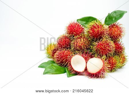 Closeup of fresh red ripe rambutan (Nephelium lappaceum) with leaves isolated on white background. Thai dessert sweet fruits. Tropical fruit.