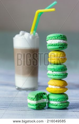 macaroons are laid by a stairs and latte in a glass