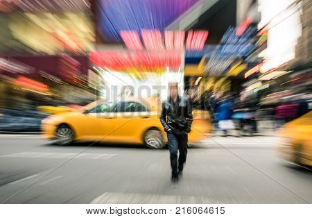 Radial blur of yellow taxicabs and unidentified person walking on 42nd street crossroad in Manhattan downtown district - Everyday commuting life New York City on rush hour in urban business area