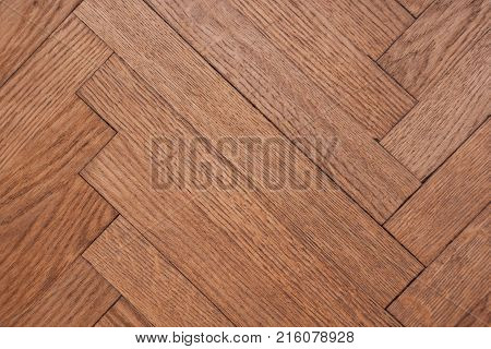 Part of the parquet in a natural wood texture laid out on the floor like a herringbone