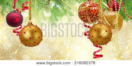 Red and golden christmas balls garland and evergreen fir tree on glowing golden background banner