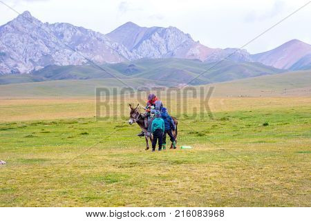 Kids And Man Riding A Donkey
