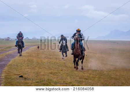 Riders Galloping In Rain, Kyrgyzstan