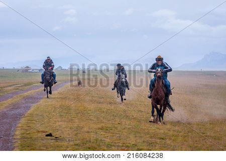 Riders Galloping In Rain, Kyrgyzstan
