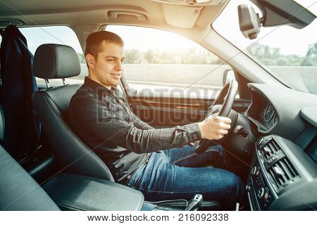 Portrait of an handsome smiling business man driving his car