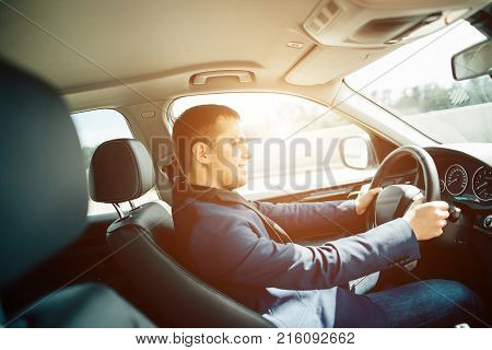 Portrait of an handsome smiling business man driving his car
