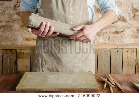 Potter Workshop Ceramics Art Concept - Standing Young Brunette Man Dressed In An Apron Male Hands Kn