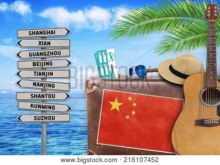 Concept of summer traveling with old suitcase and China town sign