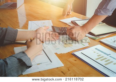 Business team discussing analysis chart with one man hand banging fist over money on desk problems stress.Defrauded cheated investor demanding money back.Business and finance concept Vintage effect.