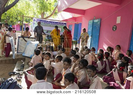PONDICHERY PUDUCHERY INDIA - SEPTEMBER 04 2017. Outdoor meeting of the children of the school with uniforms sitting on the floor waiting for sport equipments as a gift from an association.