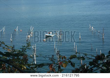 Fishing boat and small boat in the blue sea of the island Palmaria