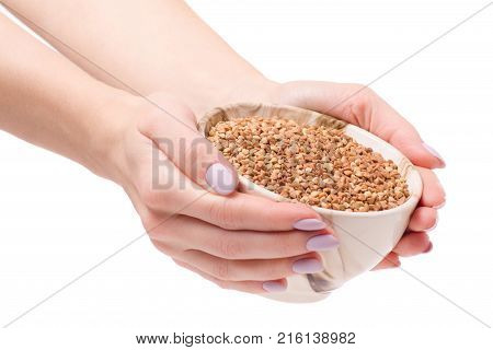 Buckwheat groats in a plate pial female hands on a white background isolation