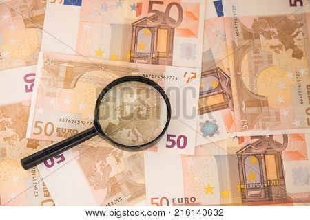 Background with euro money. Magnifier focused on keys. Euro banknotes. 50 euro.