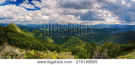 Carpathian mountains summer landscape with dramatic clouds and mossy stones. Panoramic view