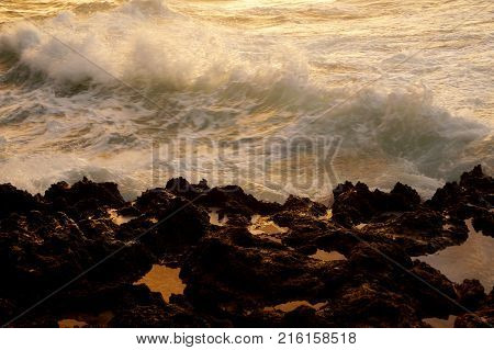 Wave break along rocky shore at Dusk on the North Shore of Oahu.