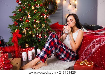Merry Christmas And Happy New Year! Young Beautiful Brunette Woman In Pajamas With A Cup Of Coffee I