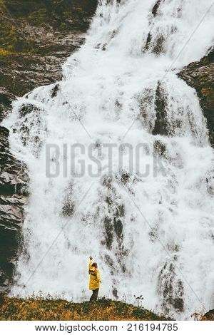Woman tourist sightseeing big waterfall outdoor Travel Lifestyle adventure concept scandinavian vacations
