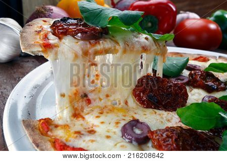 Pizza with mozzarella, rucula and dried tomato