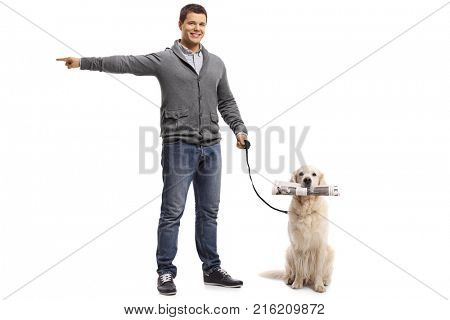 Full length portrait of a young man pointing with his hand and a labrador retriever dog with a newspaper isolated on white background