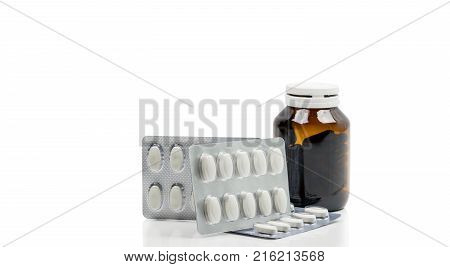 Vitamins capsule in amber glass bottle with blank label and supplements tablets in blister pack on white background. Antioxidants for healthy skin. Good supplement pills for woman bone.
