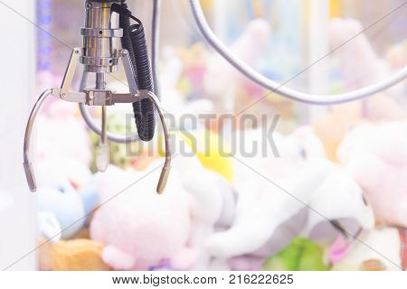 Claw Game or cabinet catches the doll.A mechanical arm selecting a random soft toy in a vending machine