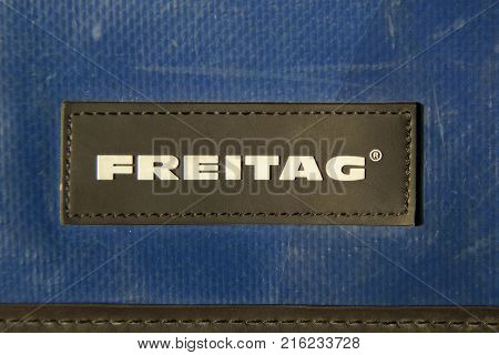 Almere, The Netherlands-  December 1, 2017: Closeup of Freitag logo sewed on a blue truck tarp messenger bag.
