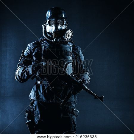 Futuristic nazi soldier gas mask and steel helmet with schmeisser handgun black background studio shot
