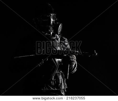 Futuristic nazi soldier gas mask and steel helmet with schmeisser handgun black background studio shot