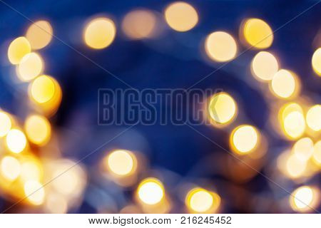 Defocused night street lights blurred colorful bokeh background. Holiday colorful lanterns and light bulbs garlands.