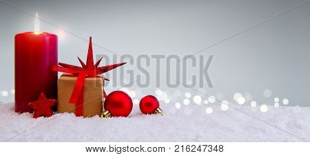 Avent candle and christmas decoration isolated on blue background. Christmas background with snow, candle and gift box .