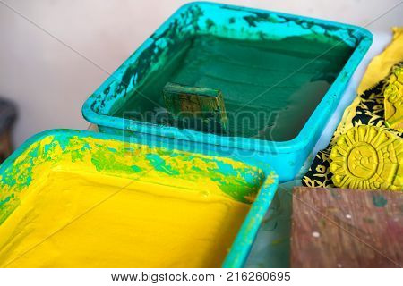 Close up stamps and bright yellow and green dye for cloth