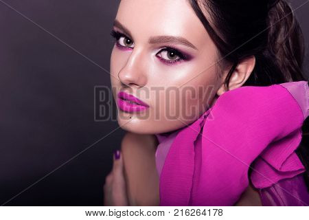 Beautiful Fashionable Girl Haired With Long Curly Hair Posing With A Pink Bow. The Girl In The Studi