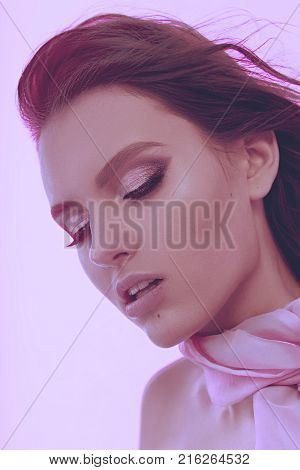 Beautiful Fashionable Girl Haired With Long Curly Hair Posing With A Pink Bow. The Girl In The Studi