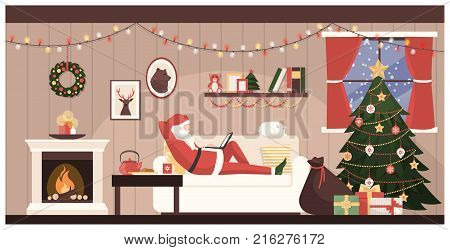 Santa Claus relaxing on the sofa at home and connecting with a laptop on Christmas eve his sack with gifts is ready
