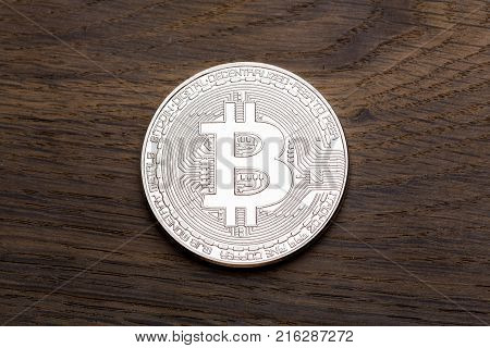 Silver cryptocurrency bitcoin on wooden background. High resolution photo.