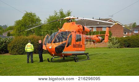 ST NEOTS, CAMBRIDGESHIRE, ENGLAND - APRIL 30, 2017:  Cambridgeshire  air ambulance Helicopter  landed in housing estate at St Neots  crew standing by.