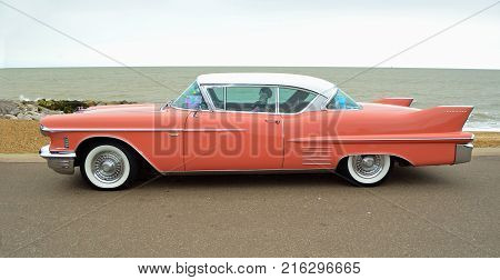 FELIXSTOWE, SUFFOLK, ENGLAND - AUGUST 27, 2016: Classic Pink Cadillac Coupe de Ville  parked on seafront promenade.