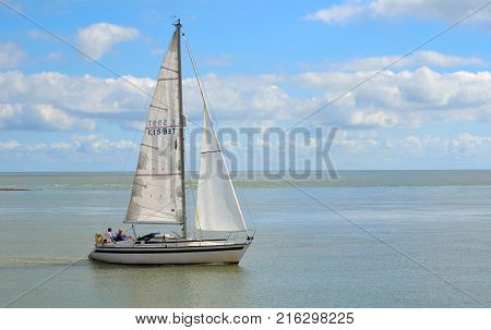 FELIXSTOWE, SUFFOLK, ENGLAND - AUGUST 29, 2016: Yacht leaving Felixstowe Ferry at the mouth of the river Deben.