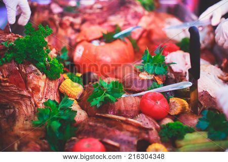 Big Giant Dish Plate With Roasted Full Pig Pork Head, Served In Restaurant With Variety Of Vegetable