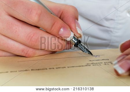 hand with fountain pen signs contract