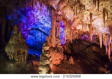 Venetsa Cave in Bulgaria. Beautiful colorful and illuminated cave full with semiprecious onyx stones. Flowstones stalactites and stalagmites lighted in different vivid colours.