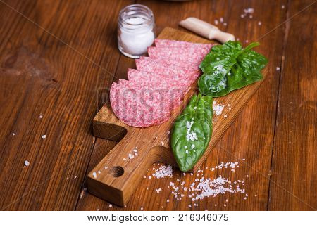 red salami sausage with fresh spinach and large salt