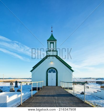 Typical green colored wooden church, Iceland in winter. Sunrise light