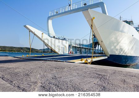 Anchored large ferryboat has open front entrance at the local port.
