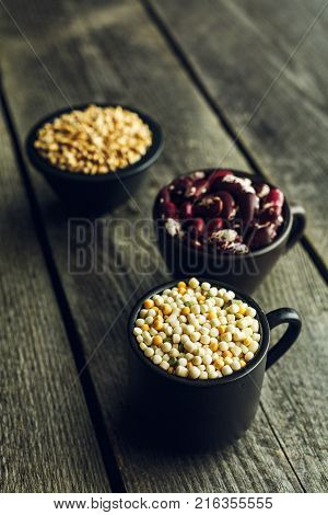 Couscous red beans and wheat grains on a wooden background