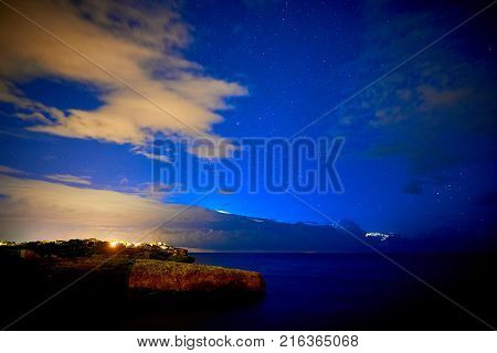 Beautiful starry sky with a thunderstorm in the sea in the background