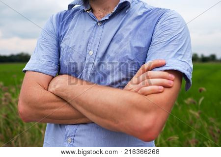 Man with hyperhidrosis sweating very badly under armpit in blue shirt because of hot weather. Travelling in asia thailand with backpacker
