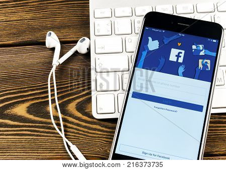 Sankt-Petersburg Russia December 2 2017: Apple iPhone 7 with Facebook homepage on monitor screen. Facebook one of the biggest social network website. Homepage of Facebook.com on smartphone